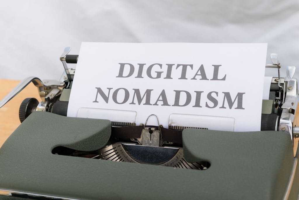 Máquina de escribir vintage, con una hoja con un texto en inglés que dice "digital nomadism" o nomadismo digital en español